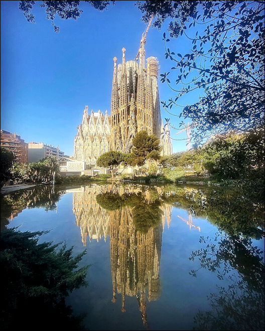 Uitzicht op de basiliek met een mooie weerspiegeling in het water van de vijver in het park voor de kerk.